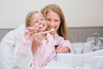 mom and daughter brushing teeth 