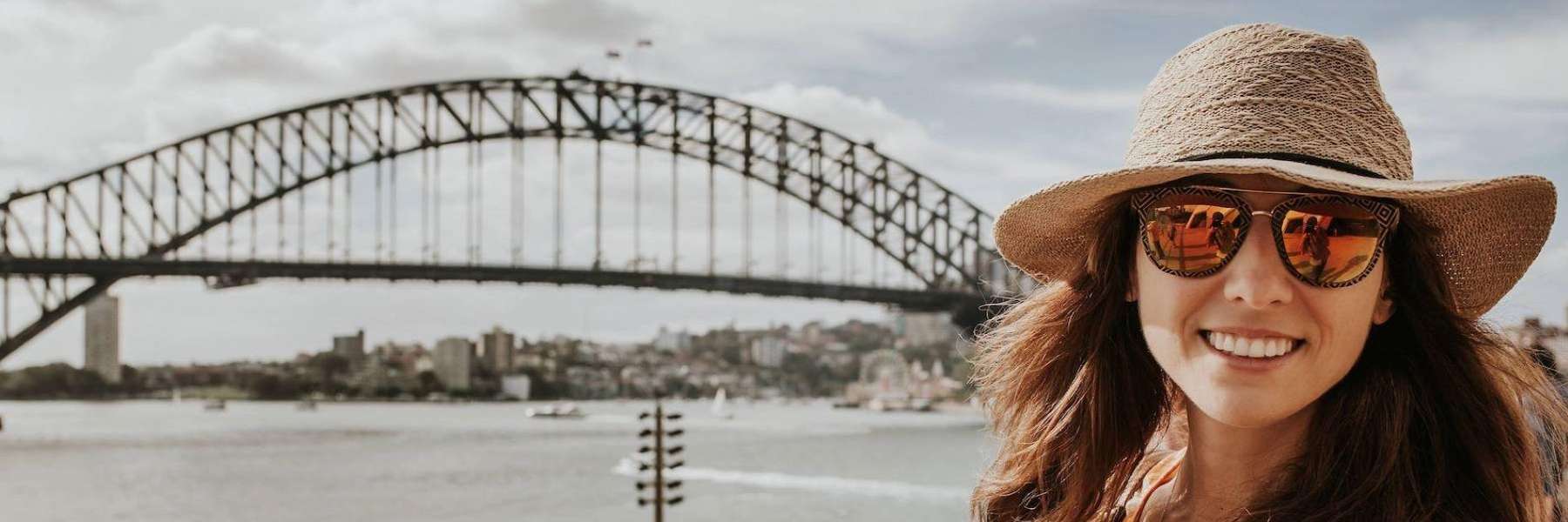 woman smiling with a bridge behind her