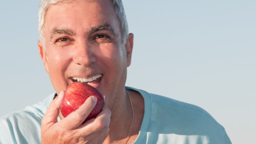 man in appleton, wi, eating apple with his secure dentures