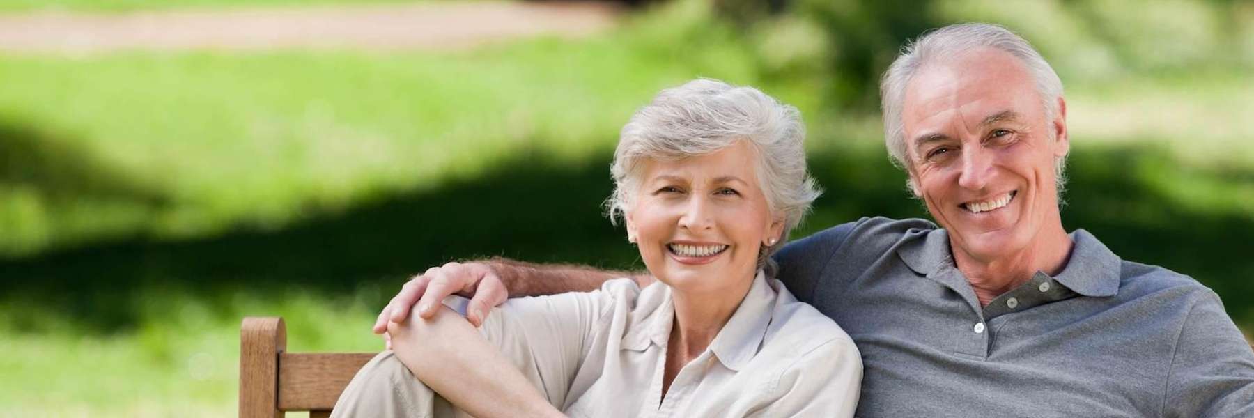 older man and woman sitting on a bench in an appleton park