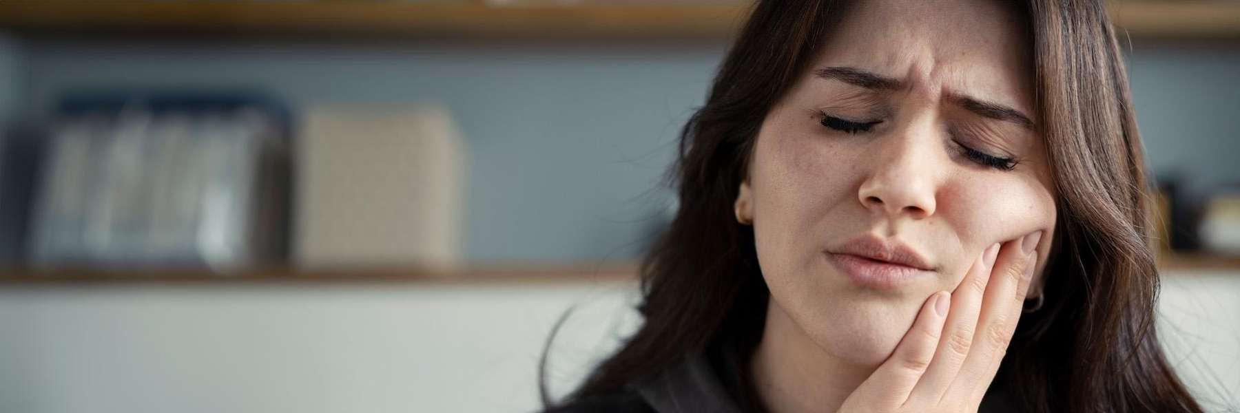 appleton woman holding her jaw from tooth pain during an emergency