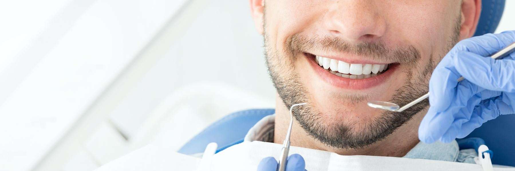 man getting teeth looked at during an exam